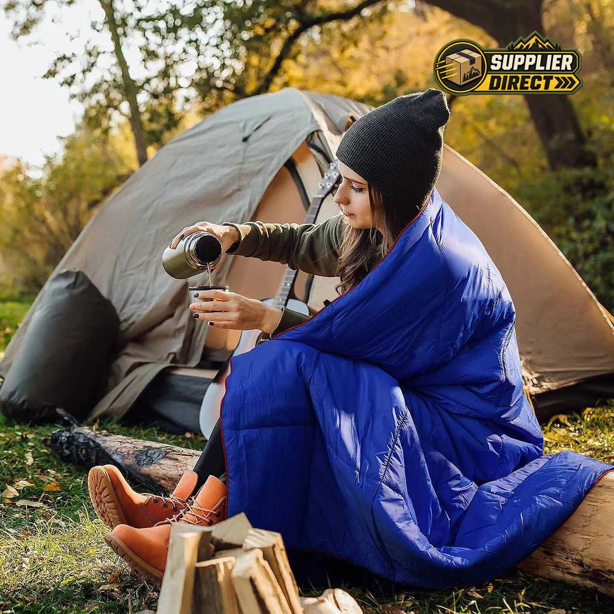 PrepPro Australia wearable blue quilted camping blanket draped over a woman sitting by a tent outdoors