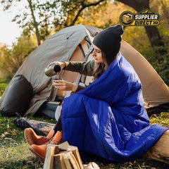 PrepPro Australia wearable blue quilted camping blanket draped over a woman sitting by a tent outdoors