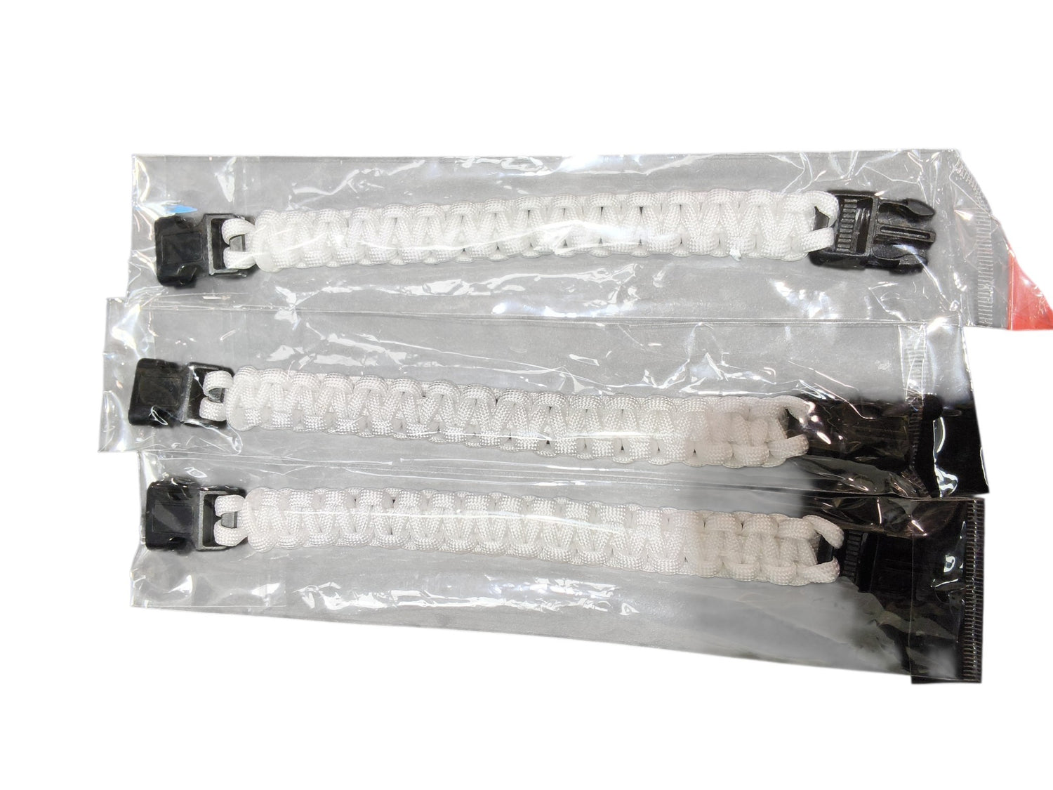 Three PrepPro Australia white paracord survival bracelets in individual clear plastic packaging with black buckles.