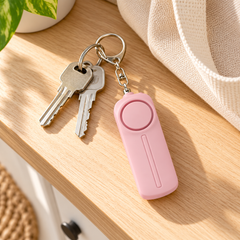 Pink personal alarm with house keys on an entryway table