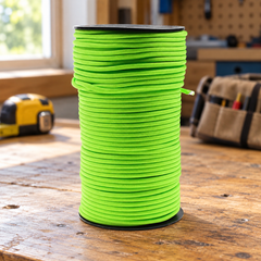 100m Outdoor Paracord Survival Rope - Green on a garage workbench