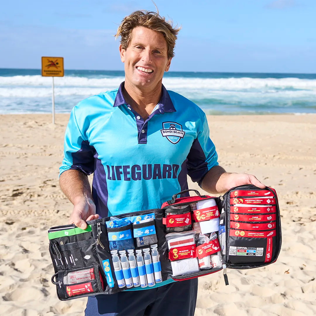Lifeguard holding the open SURVIVAL First Aid KIT Large